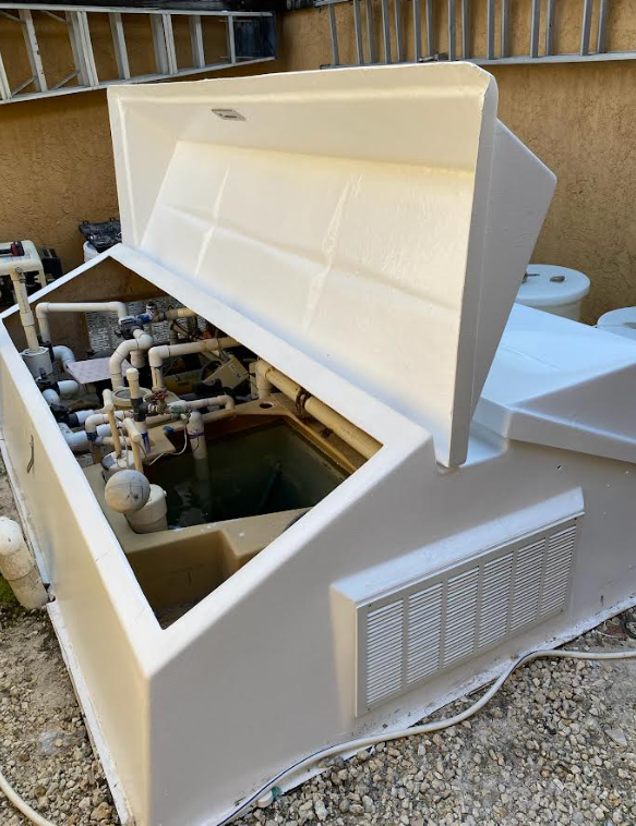 Open refurbished Vak-Pak fiberglass equipment vault showing the pool equipment inside